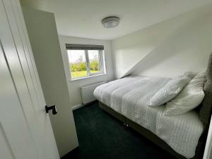 Un dormitorio pequeño con una cama y una ventana. en Kennedy Farm Lodge, en Carmavy 7 fotos más