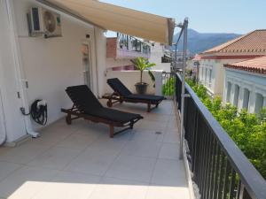 a balcony with two lounge chairs on a building at Petmeza Top Aigio City F in Aigio