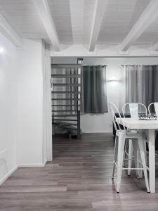 a dining room with a white table and chairs at Prestige house 10 appartamento in Scalea +13 photos