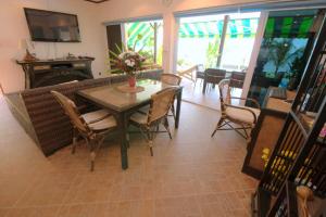 a dining room with a table and chairs and a couch at Beachfront Oasis with Private Pool and Jacuzzi on Samuis Bang Por Beach in Ban Bang Po