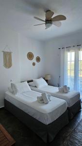 a bedroom with two beds and a ceiling fan at Enalia Studio in Korissia