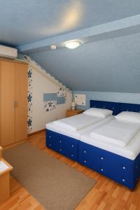 two beds in a room with blue walls and wooden floors at Cabana Ogradena in Eşelniţa