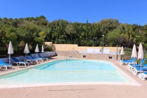 a large swimming pool with chairs and umbrellas at Casa Maedo in Santa Maria