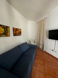 a living room with a blue couch and a tv at Casa Maedo in Santa Maria