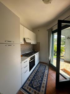 a kitchen with white cabinets and a door to a patio at Casa Maedo in Santa Maria