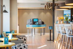 ein Restaurant mit Tischen und Stühlen und einer Kasse in der Unterkunft Hey Lou Hotel Piding in Piding