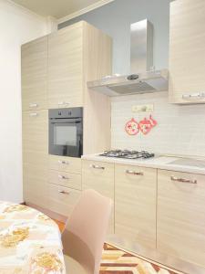 a kitchen with wooden cabinets and a stove top oven at Casa Linda in Lido di Ostia