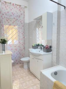 a bathroom with a sink and a toilet and a mirror at Casa Linda in Lido di Ostia