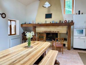 a kitchen with a wooden table and a fireplace at Longère de charme - Périgord in Vergt