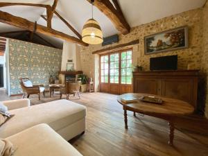 a living room with a couch and a table at Longère de charme - Périgord in Vergt