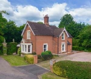 a brick house with a chimney on top of it at Hanley Swan, The Garden Flat in Madresfield