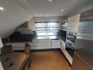 a kitchen with white cabinets and a table and a sink at Panorama Wohnung in Künzelsau