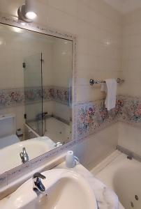 a bathroom with a sink and a mirror and a tub at Quinta da Regada in Arcos