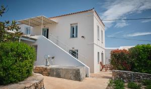 a white house with a staircase in front of it at Maira Arch House in Potamós
