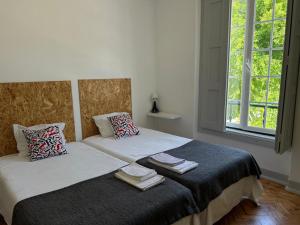 two beds sitting next to each other in a bedroom at Hostel Rossio Alcobaça in Alcobaça