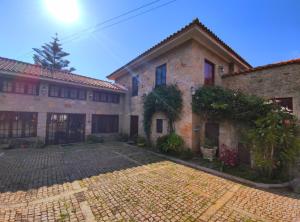 an old stone house with a cobblestone yard at Quinta da Regada in Arcos