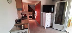 a kitchen with a sink and a tv in a room at T3 dans villa proche Calvi mer piscine in Montegrosso