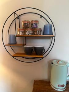 a wall mounted shelf with bowls and jars on it at The Briery in Workington