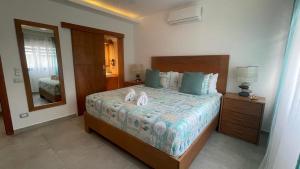 a bedroom with a large bed and a mirror at Nicole Residence in Las Terrenas