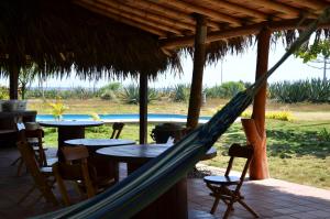 a hammock in a resort with a pool at Casa Roja Hostel in Montañita