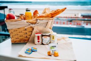 a basket of food and bread on a table at Résidence Odalys De La Plage in Pornichet