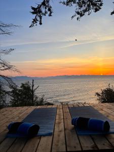a group of blue yoga mats on a dock with the ocean at Sea 'N' Stars BNB in Gabriola