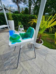 een witte stoel met een groene zitting op een terras bij Galactic Sea in Comacchio