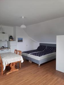 a bedroom with two beds and a table in it at Chabrowa Perła in Jarosławiec