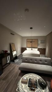 een grote slaapkamer met 2 bedden en een tafel bij شقق اكتارا Actara in Jazan