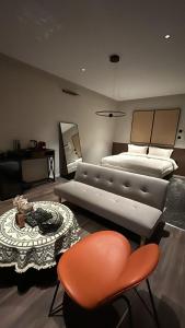 een slaapkamer met een bed, een tafel en een bank bij شقق اكتارا Actara in Jazan
