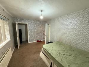 a bedroom with a bed and a brick wall at Near Hylands hotel family room in Nottingham