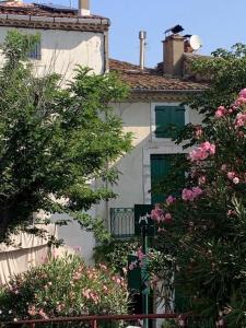 a white building with pink flowers in front of it at Byhus - det genuina Frankrike in Laurens