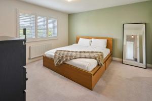 a bedroom with a large bed and a mirror at Host & Stay - Maison de Cobbe in Winchester