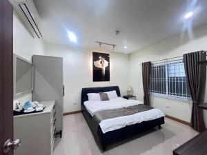 a bedroom with a bed and a desk in it at Paradise Hotel & Apartment in Vientiane