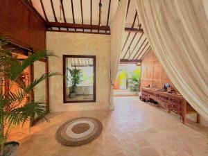Una gran sala de estar con una mesa y una cortina. en BaraJade Villa, en Uluwatu 8 fotos más