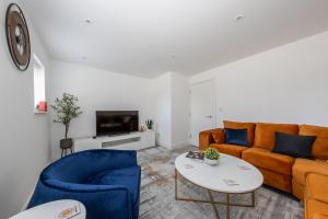 a living room with two couches and a table at CONTRACTORS FAVOURITE, LUXURY LIVING, LARGE PREMIUM HOUSE, NEWLY BUILT, FREE PARKING FOR UP TO 4 VEHICLES, GREAT ACCESS TO CENTRAL LUTON & THE M1 and A6 in Luton