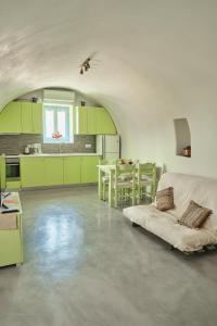 a kitchen with green cabinets and a couch in a room at Maira Arch House in Potamós