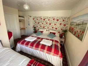 a bedroom with a bed with a plaid blanket at Cornerways Guest House St Austell Cornwall in St Austell