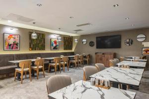 a restaurant with tables and chairs and a flat screen tv at Garner Hotel Istanbul - Airport Arnavutkoy by IHG in Istanbul