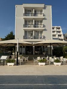 a building with tables and umbrellas in front of it at DIELL HOTEL in Durrës