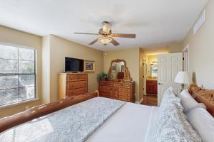 ein Schlafzimmer mit einem Bett und einem Deckenventilator in der Unterkunft Top of the Foothills in Tucson