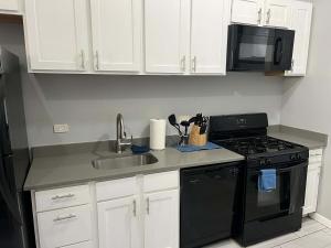 a kitchen with a sink and a stove and a microwave at South Loop 2 Bedroom Apt in Chicago