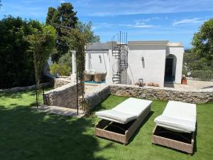 a backyard with two lounge chairs and a house at Villa Claudia in Anacapri