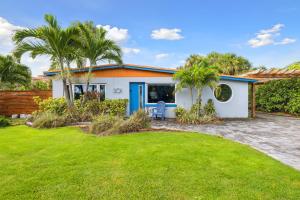 a house with palm trees in front of a yard at Steps From The Beach & 3 Miles To Cruise Ports! in Cocoa Beach