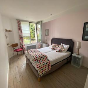 a bedroom with a bed and a chair and a window at Villa Ker Zen 300m de la plage in La Baule