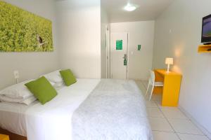 a bedroom with a large white bed with green pillows at Che Lagarto Hostel Ipanema in Rio de Janeiro