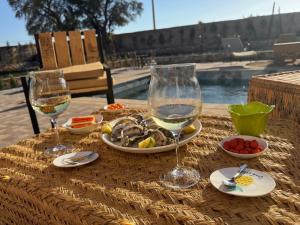 une table avec deux verres de vin et des assiettes de nourriture dans l'établissement Sweety Mogador, à Essaouira