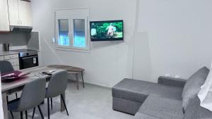 a kitchen and a living room with a couch and a table at Beach Getaway in Nea Irakleia