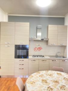 a kitchen with white cabinets and a table with chairs at Casa Linda in Lido di Ostia +16 photos