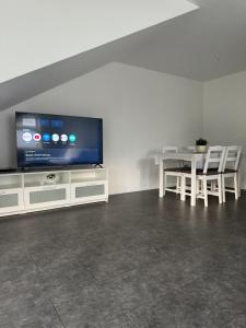 a living room with a television and a table and chairs at Komplett neu renovierte Wohnung! in Hannover